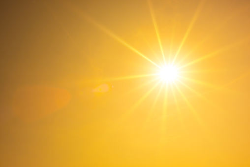 Summer background, orange sky with glowing sun